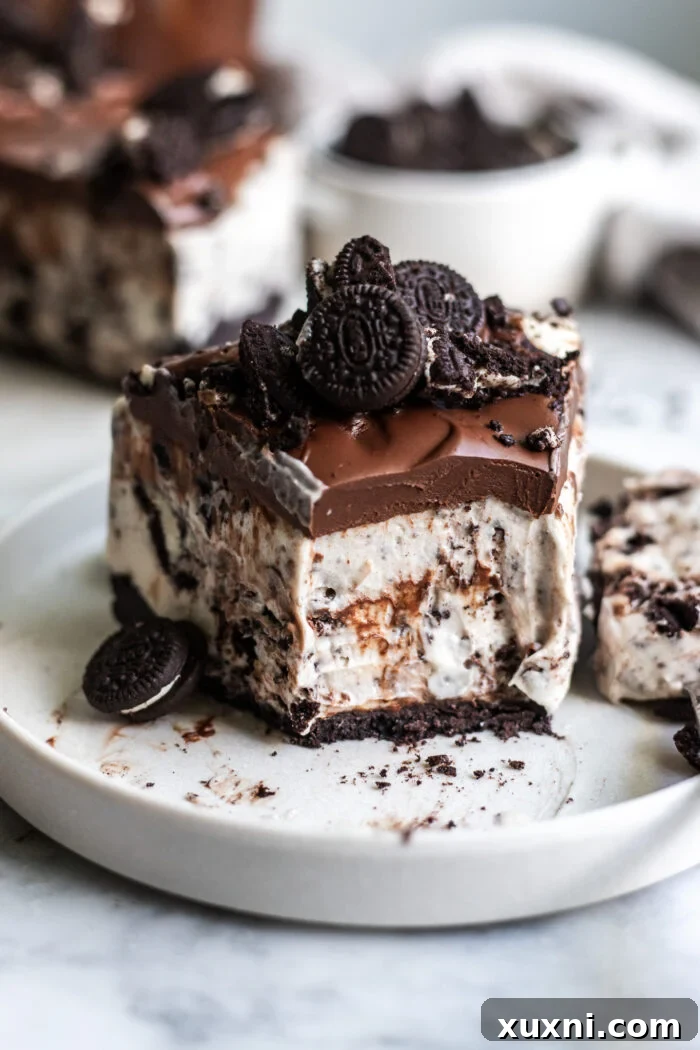 A pristine slice of vegan Oreo cheesecake on a white plate, showcasing its beautiful layers and topping, ready to be served.