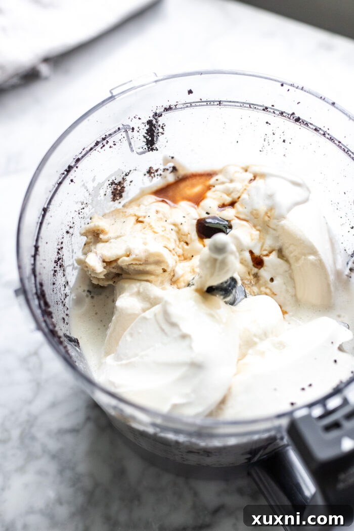 Various cheesecake ingredients beautifully blended together in a food processor, showcasing the creamy, smooth texture of the vegan filling.