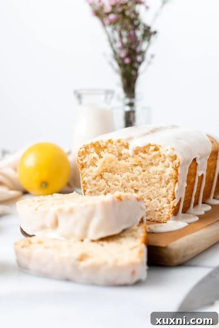 Sliced Vegan Lemon Pound Cake topped with vanilla glaze, revealing its moist and tender crumb.