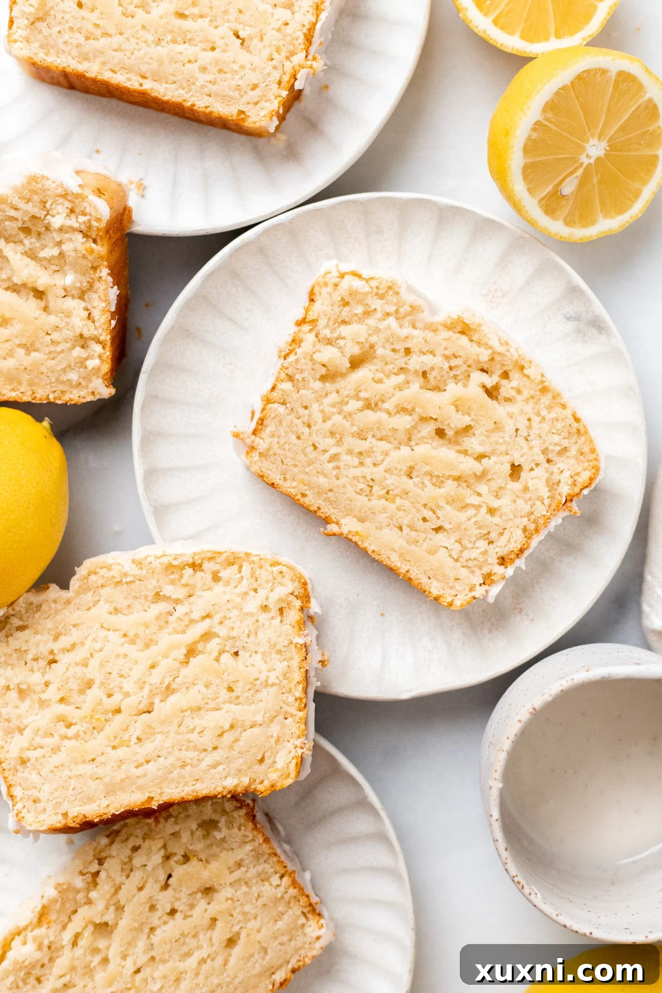Close-up of a single slice of vegan lemon pound cake with glaze, ready to be enjoyed.