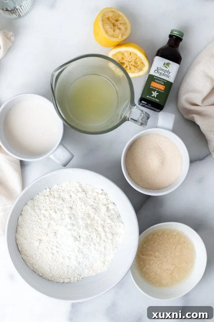 Assortment of fresh ingredients for vegan lemon pound cake, including lemons, flour, sugar, and vegan butter.