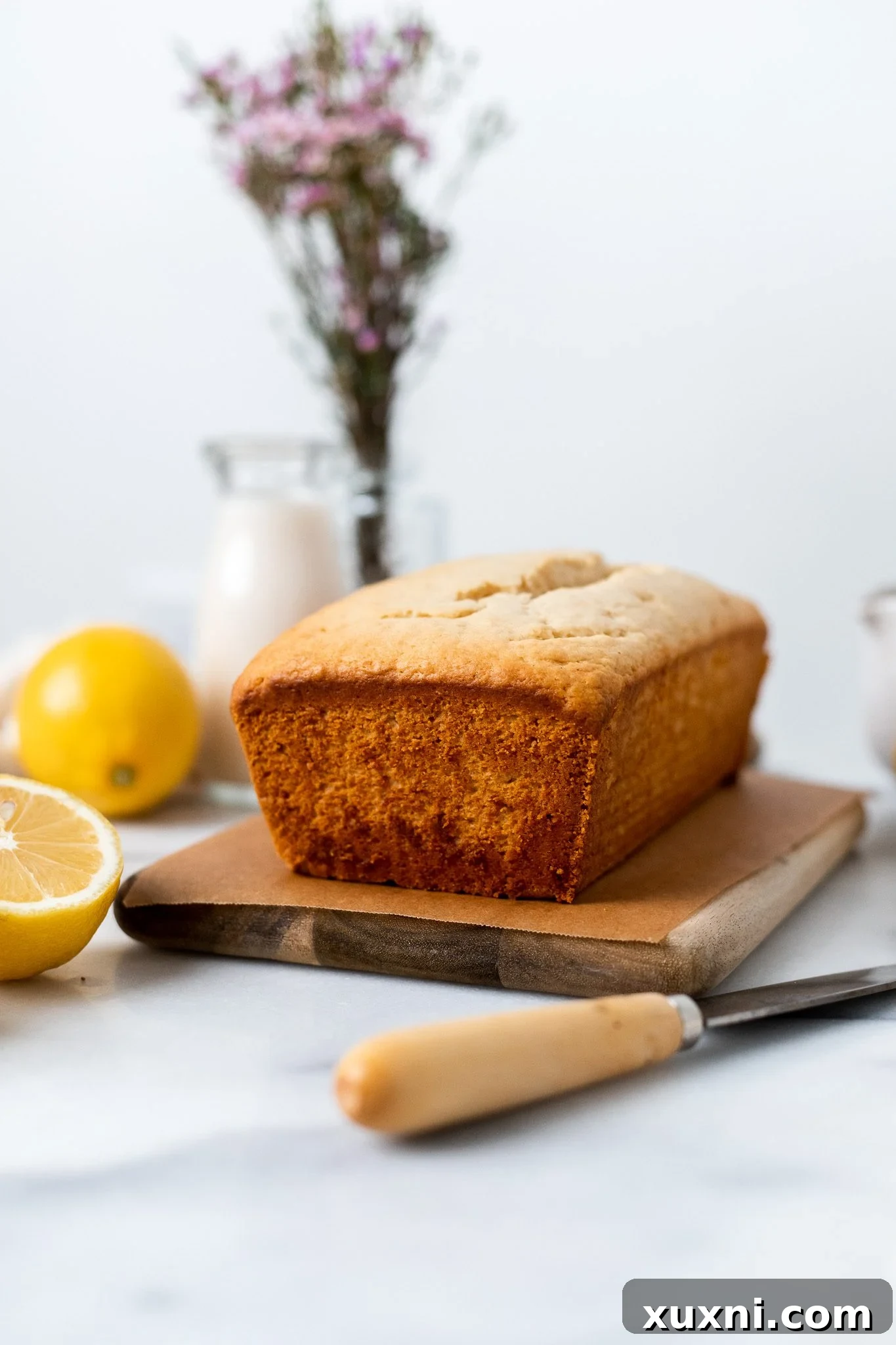 Baked vegan lemon pound cake on a cooling rack, showing its perfect golden crust.