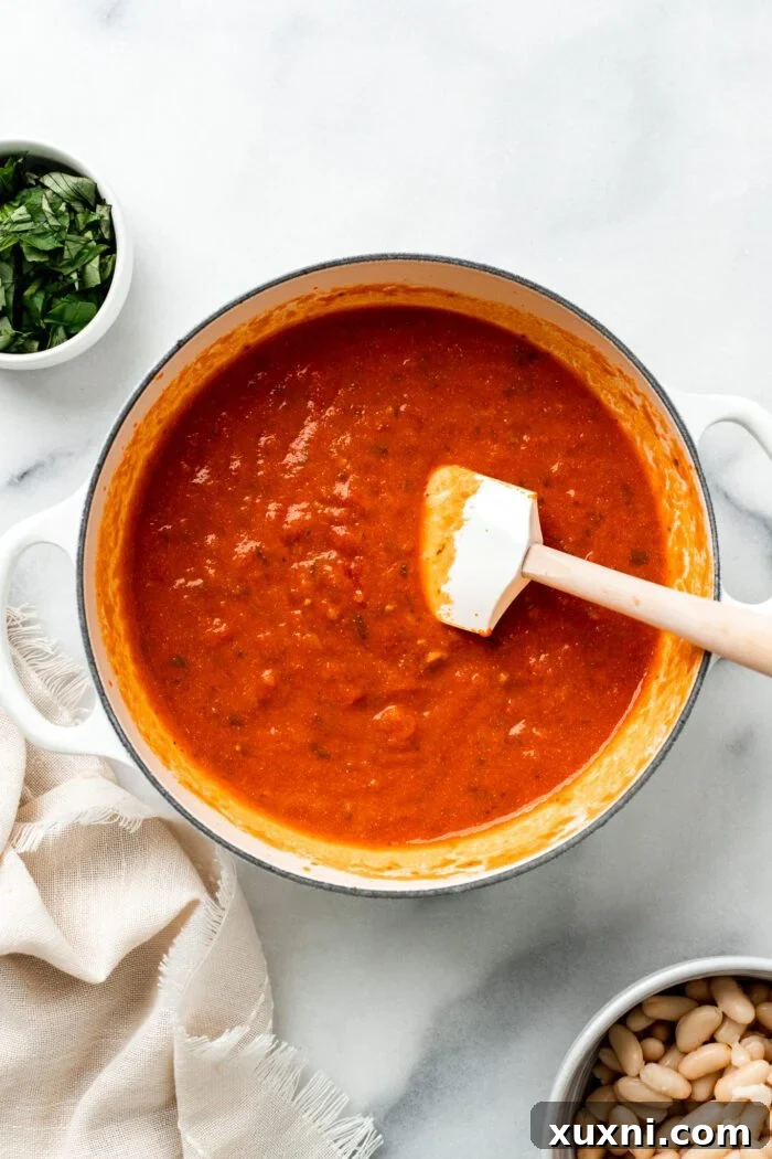 25-Minute No-Boil Vegan Cheesy Baked Gnocchi with Beans 6 Mixing marinara sauce and vegan liquid mozzarella into sautéed garlic in a Dutch oven.