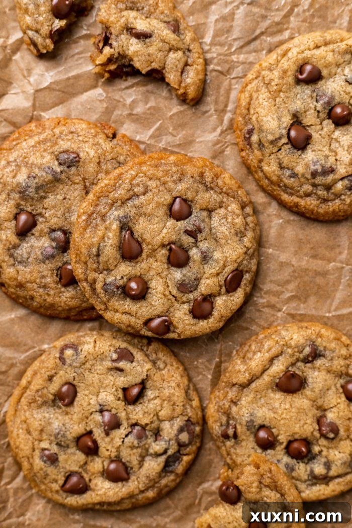 Freshly baked small batch chocolate chip cookies on parchment paper, ready to be enjoyed.