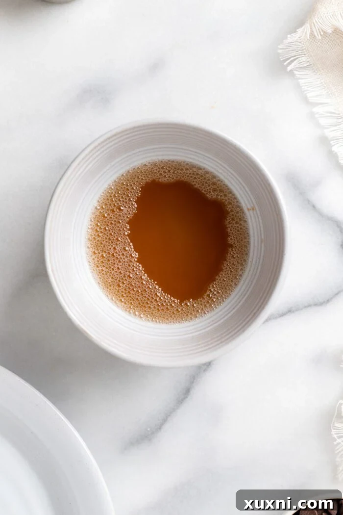 Browned vegan butter in a bowl, cooling and starting to solidify at room temperature.