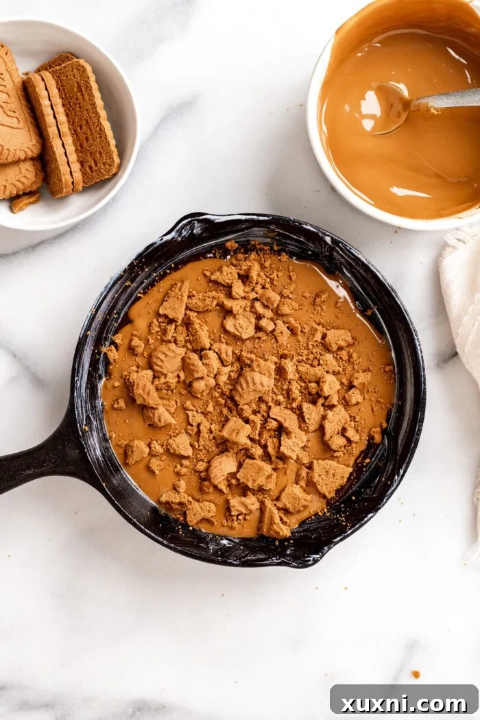 Melted Biscoff butter and crushed cookies on top of the first layer of brownie batter.