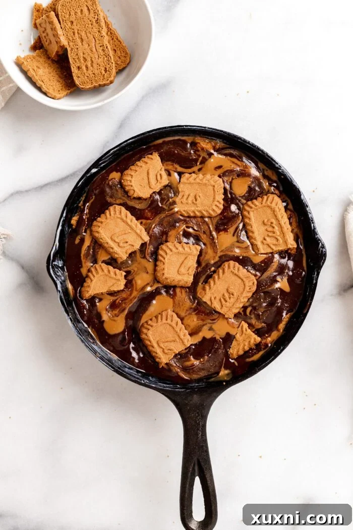 Biscoff brownies topped with whole cookies before baking.