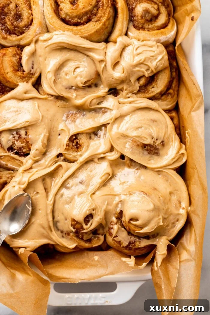 Finished banana bread cinnamon rolls generously topped with peanut butter frosting