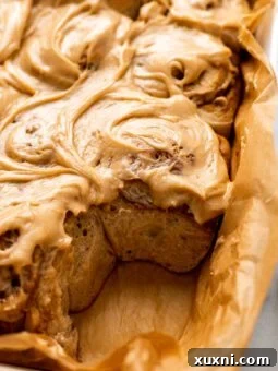 A freshly baked vegan banana bread cinnamon roll with white frosting