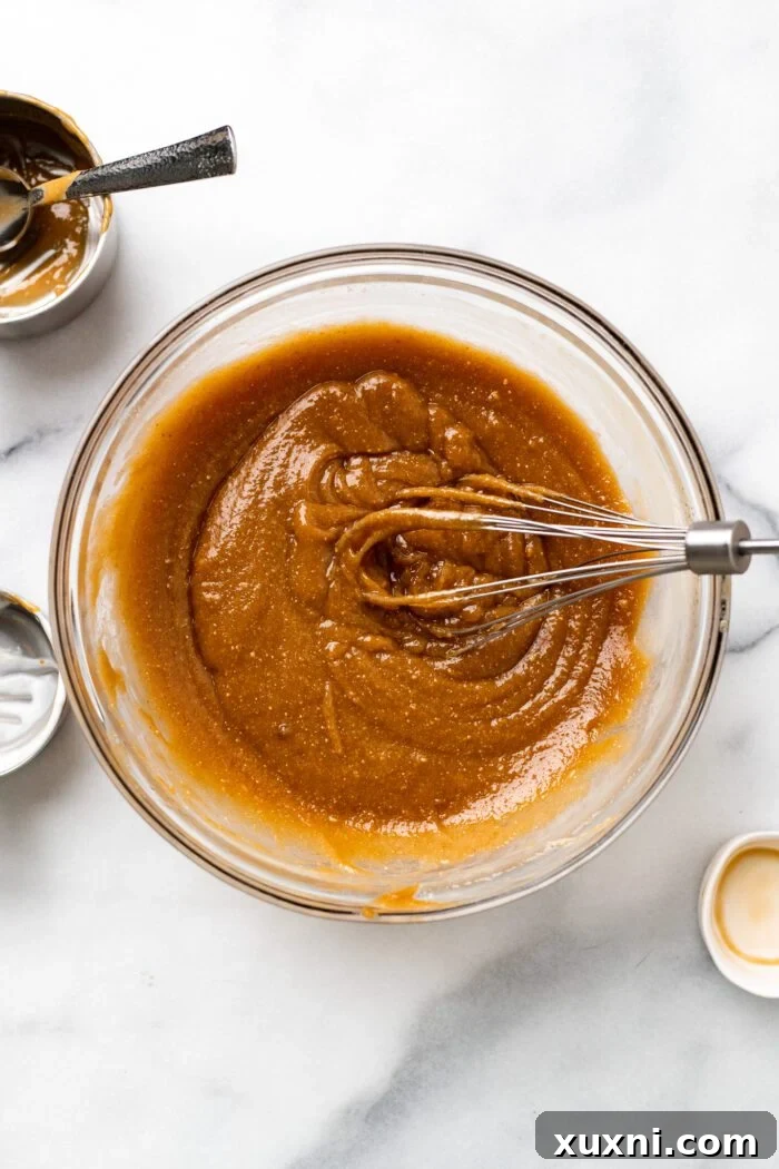 Adding creamy peanut butter and vanilla extract to the wet ingredients and whisking