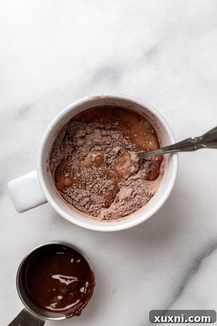 Dairy-free milk being poured into the mug with dry ingredients