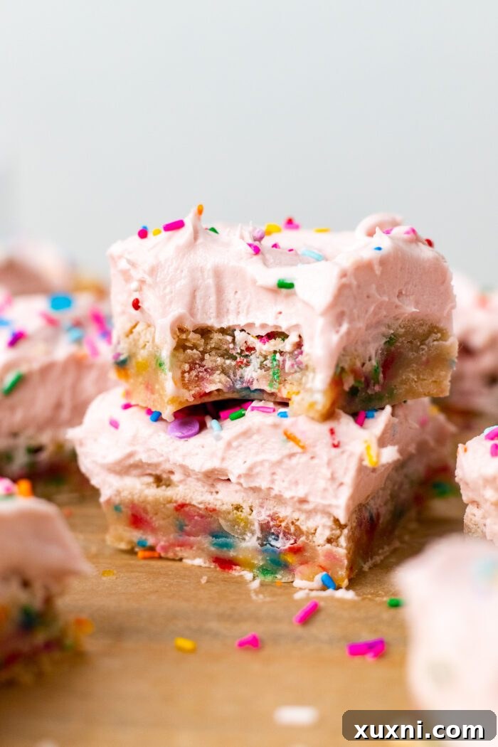 Stacked vegan sugar cookie bars showcasing their soft texture and creamy pink frosting, a perfect egg-free and dairy-free dessert.