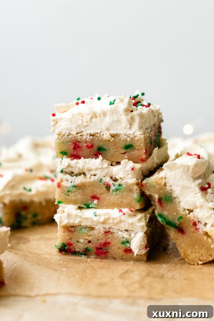 Close-up of baked vegan sugar cookie bars with festive red and green sprinkles folded into the dough, on parchment paper.