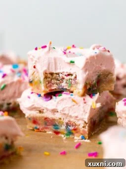 Stacked vegan sugar cookie bars with rich pink cream cheese frosting, a perfect egg-free and dairy-free dessert.