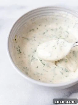 bowl of yogurt dill sauce with a spoon in it