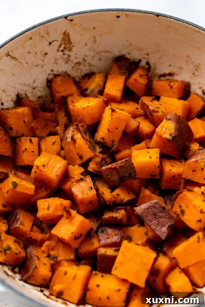 Crispy roasted sweet potatoes served in a rustic Dutch oven, showcasing their golden-brown and slightly caramelized edges.