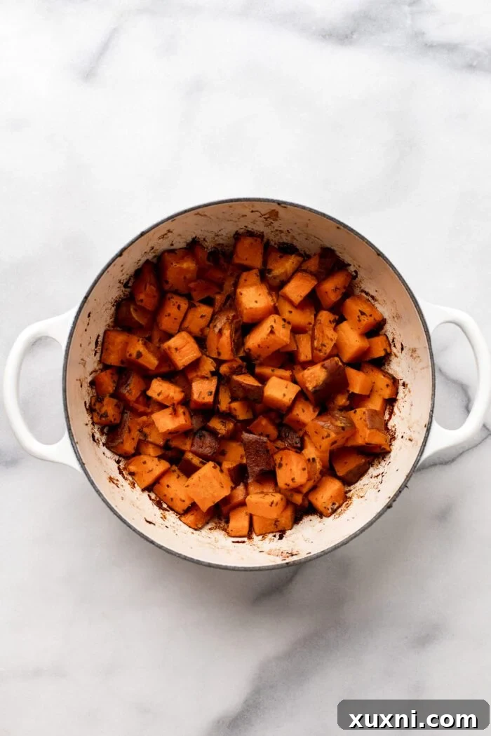 Perfectly roasted crispy sweet potatoes in a Dutch oven, golden brown and ready to be served and enjoyed.
