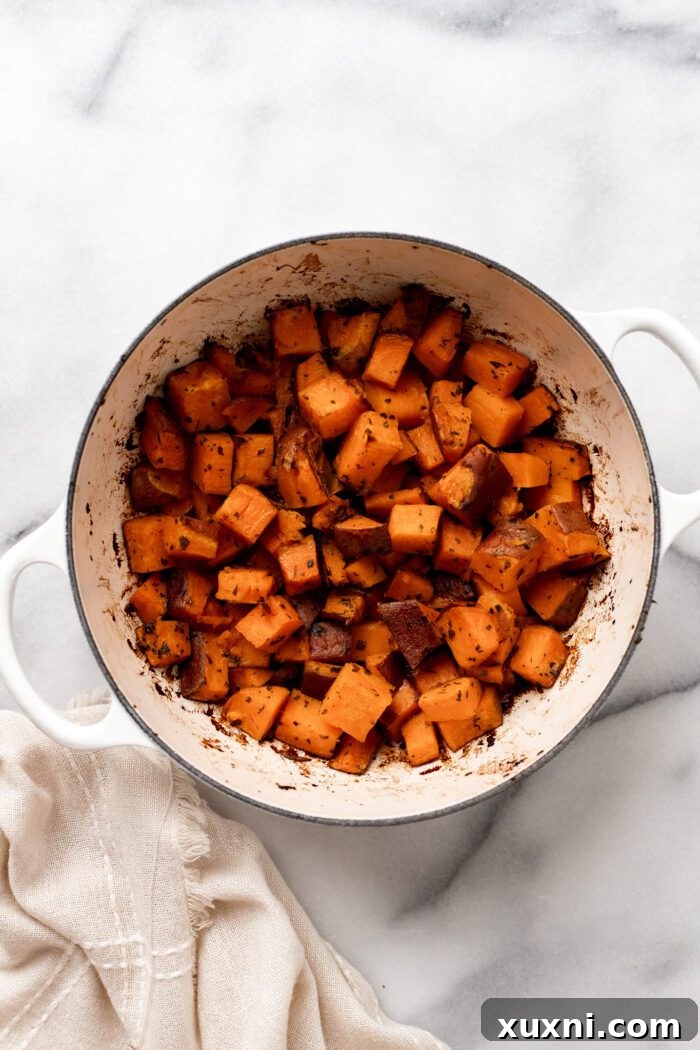 A close-up of perfectly golden and caramelized oven-roasted crispy sweet potatoes in a serving bowl, ready to be enjoyed.