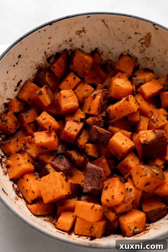 Close-up of golden-brown crispy roasted sweet potatoes in a serving dish, highlighting their irresistibly crisp texture and delicious appearance.
