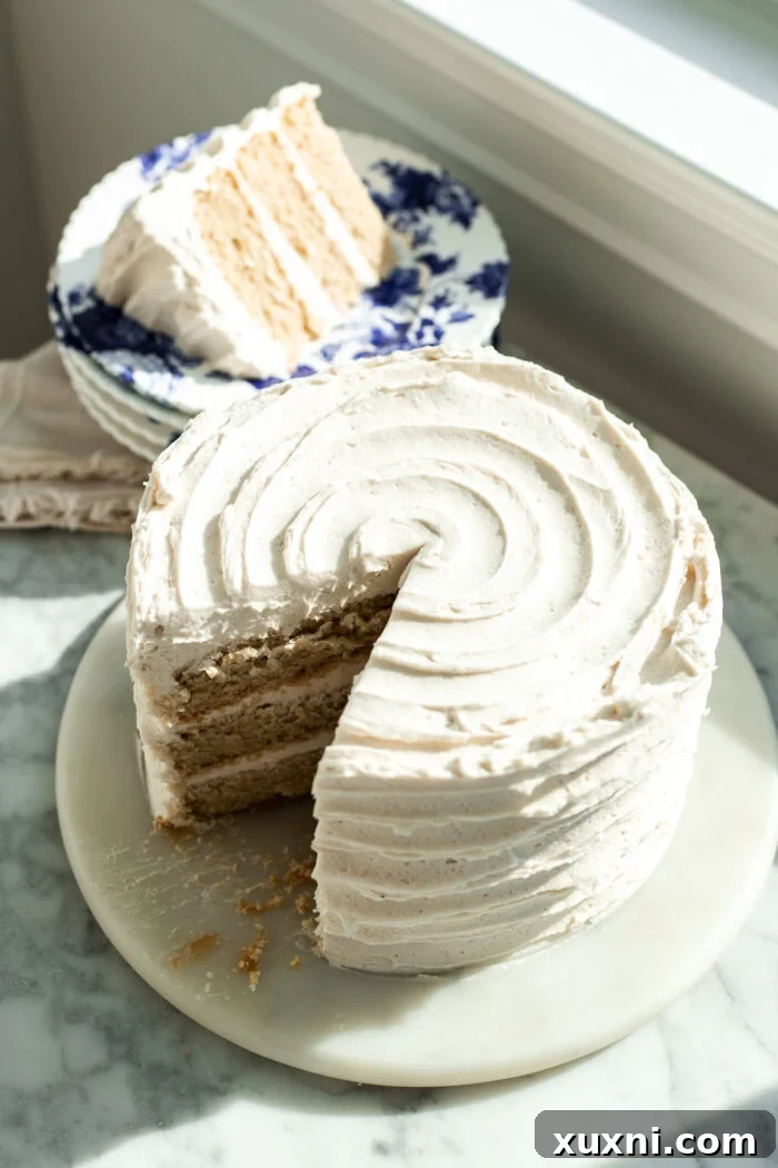 A moist and fluffy slice of vegan vanilla cake on a minimalistic background.