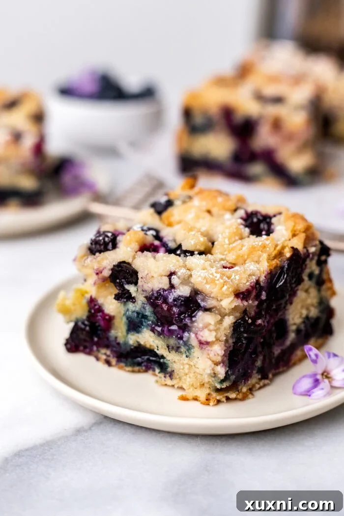 Plate of vegan blueberry buckle with a bite taken, showcasing its delicious layers