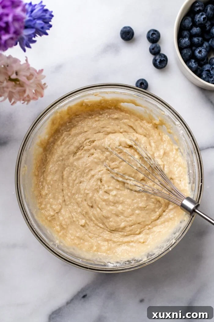 Dry ingredients being added to wet batter for blueberry buckle