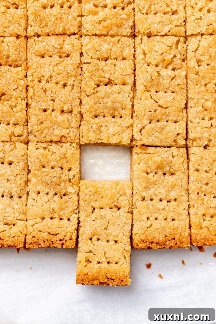 Stacked vegan shortbread biscuits on a white plate, showcasing their inviting texture.