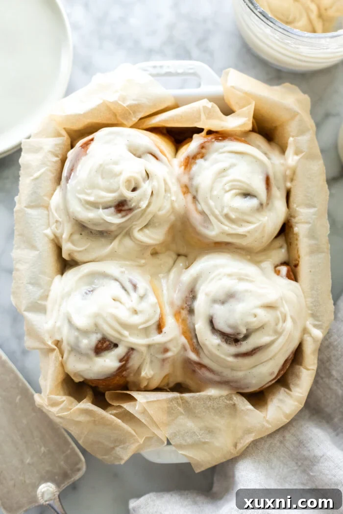 Frosted vegan small batch brown butter cinnamon rolls on a plate, showcasing their gooey texture