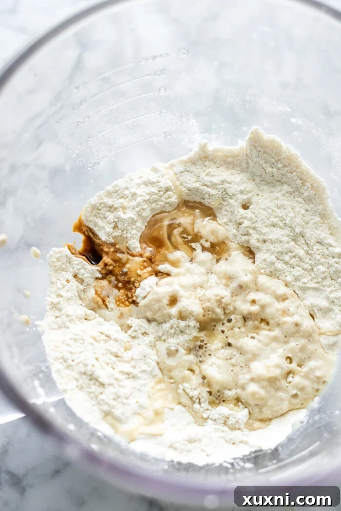 Vegan cinnamon roll dough being mixed in a stand mixer, demonstrating the initial stage of dough preparation