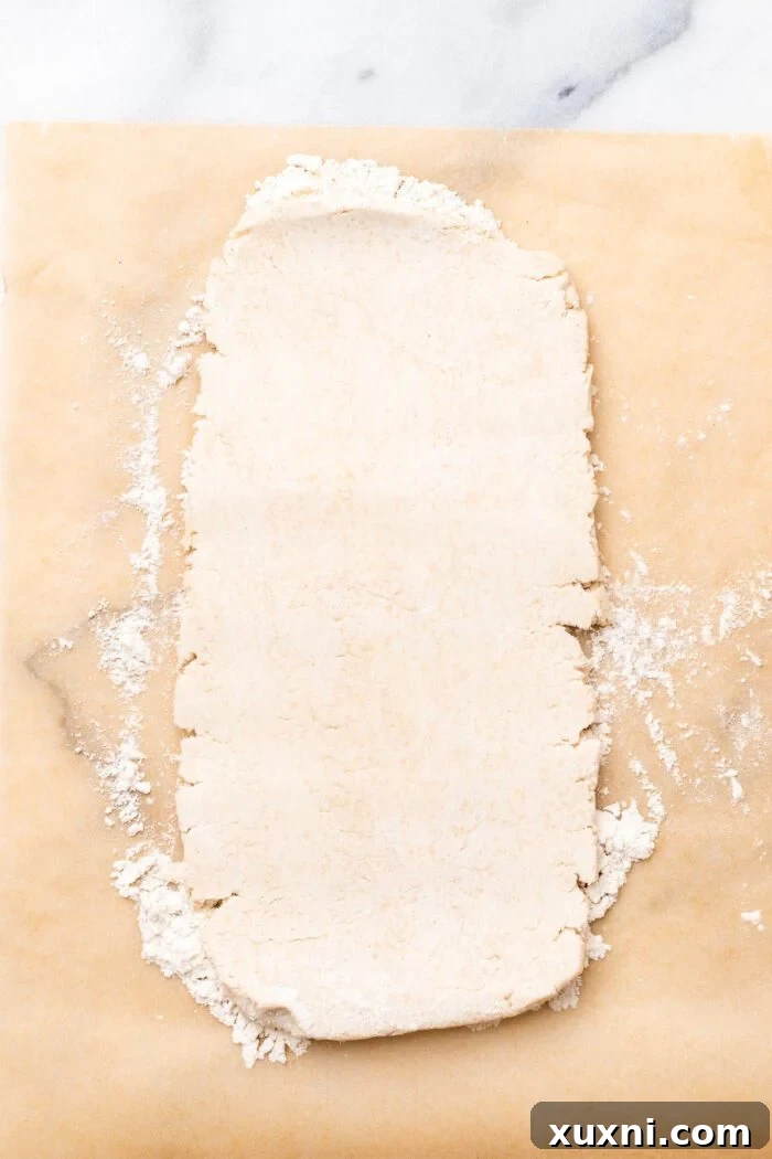 Rolled out rectangular puff pastry dough on a floured surface.