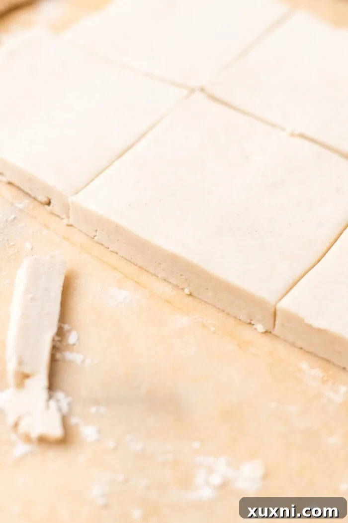 Gluten-free puff pastry rolled out thinly on a baking sheet, ready for shaping.