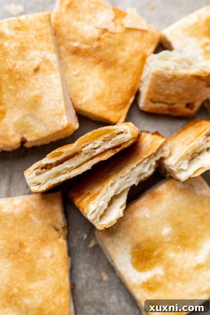 Close-up of baked and sliced flaky puff pastry, revealing golden layers and airy texture.