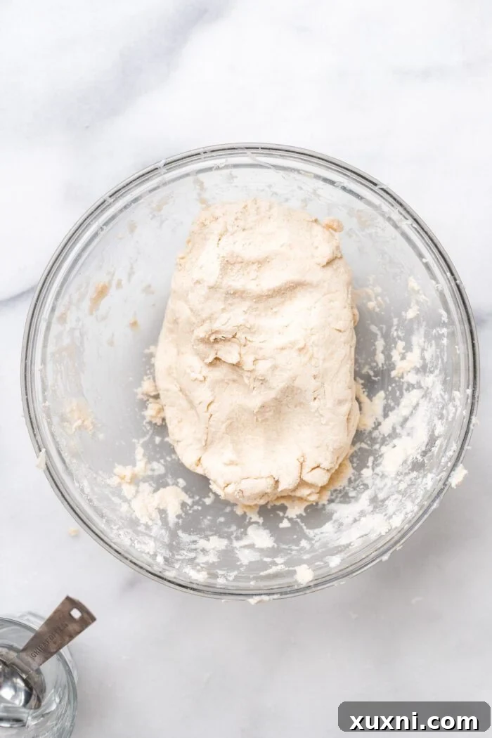 Kneaded gluten-free puff pastry dough formed into a ball in a bowl.