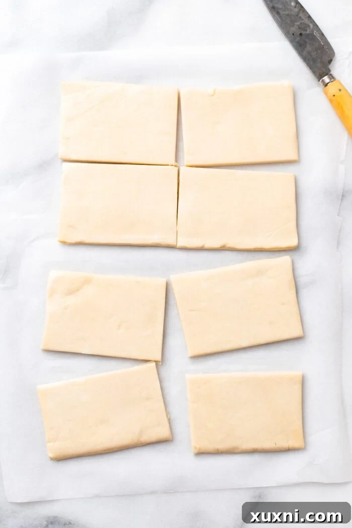 A sheet of rolled-out puff pastry, ready to be sliced for Danish pastries.
