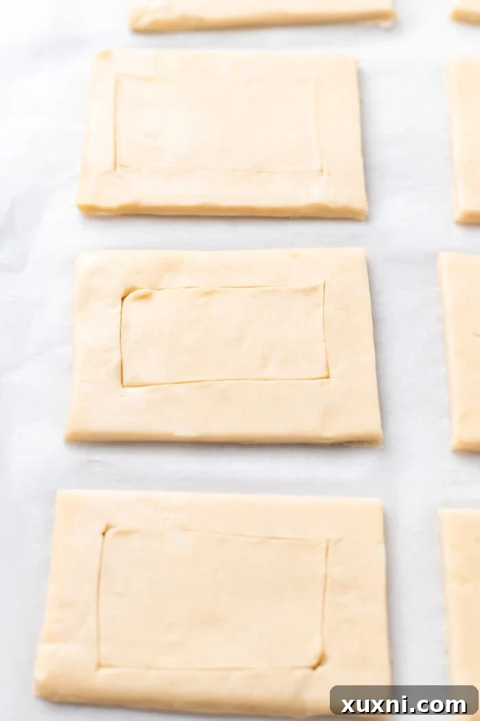 Scoring the edges of puff pastry rectangles to create a border for the filling.