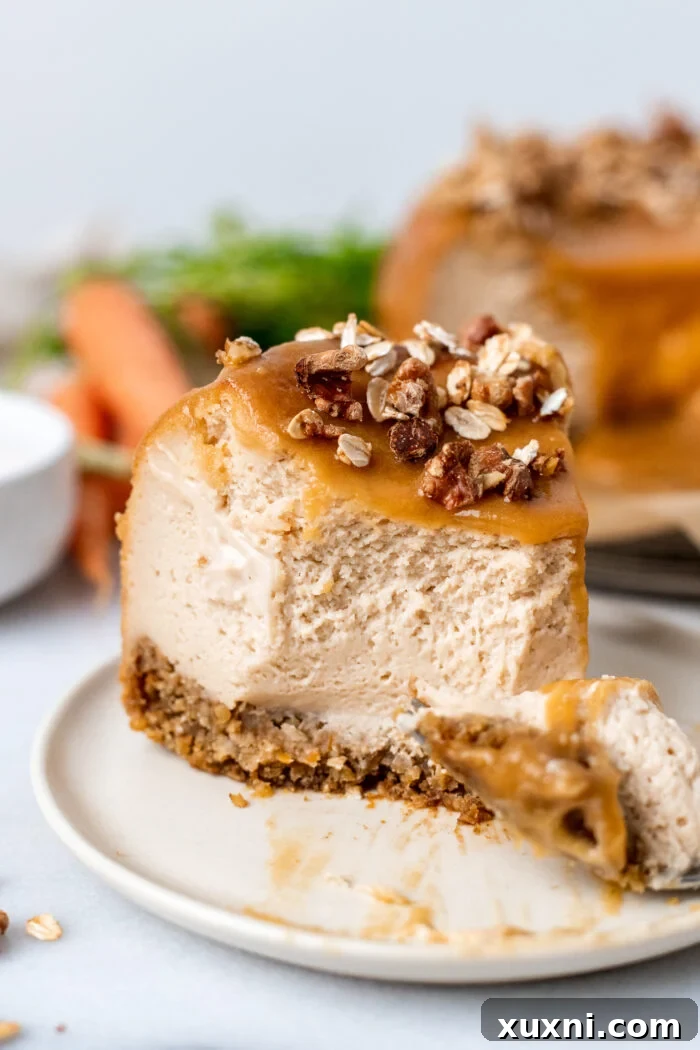 A delicious slice of vegan carrot cake cheesecake on a plate with salted caramel drizzle and toasted oats.