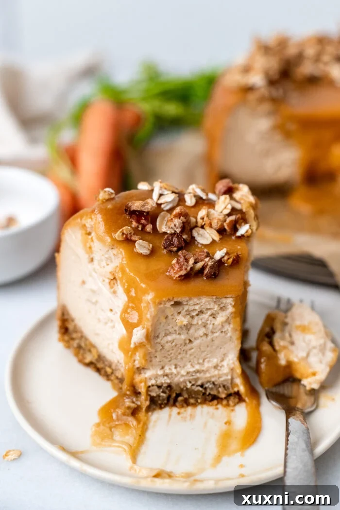 A close-up shot of a single slice of carrot cake cheesecake on a white plate, highlighting the layers and toppings.