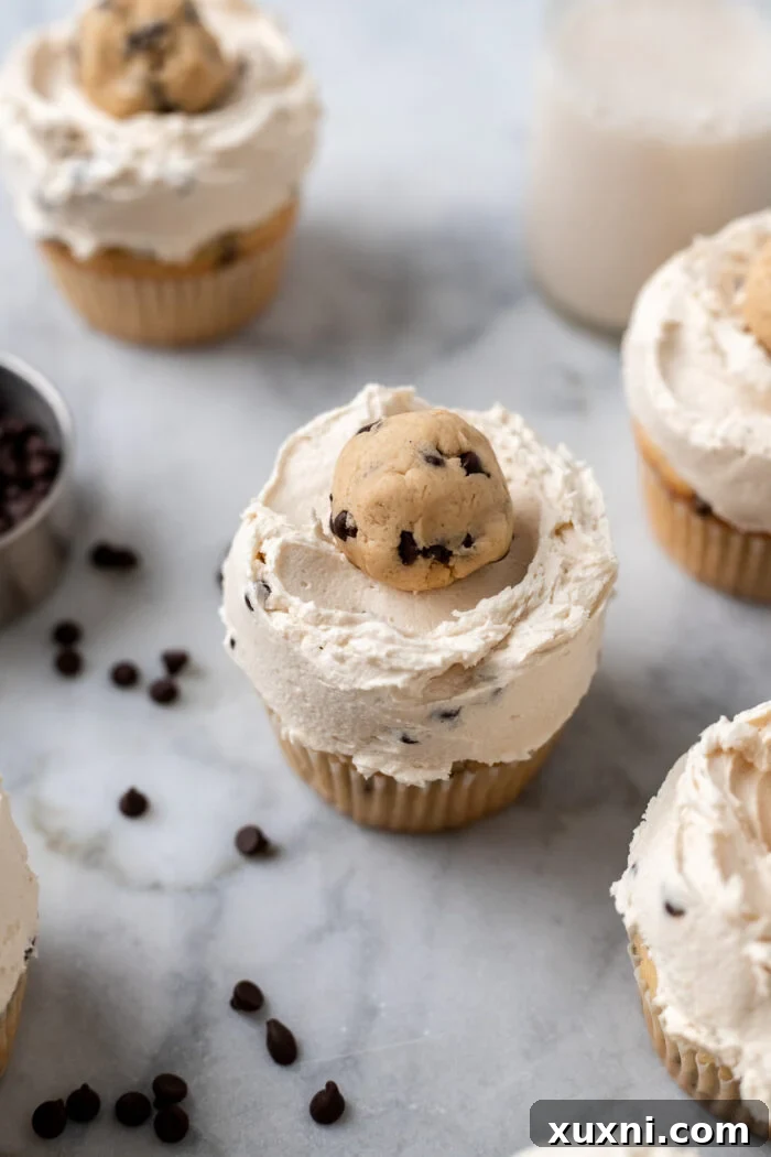 Six cookie dough cupcakes beautifully frosted and arranged, ready to be served.