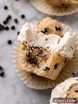 Bitten cookie dough cupcake in its liner, showcasing the molten center