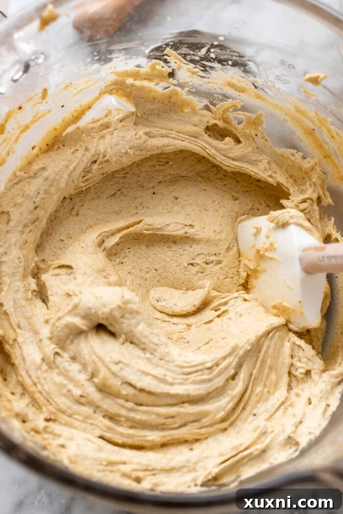 Creamy vegan pistachio cream cheese frosting in a mixing bowl.