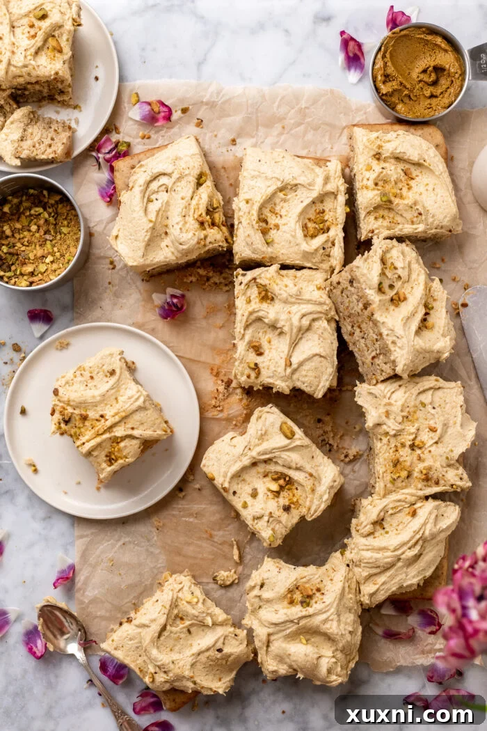 An array of vegan pistachio cake slices, garnished with crushed pistachios.