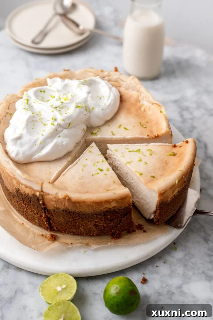 Sliced vegan key lime cheesecake garnished with lime zest