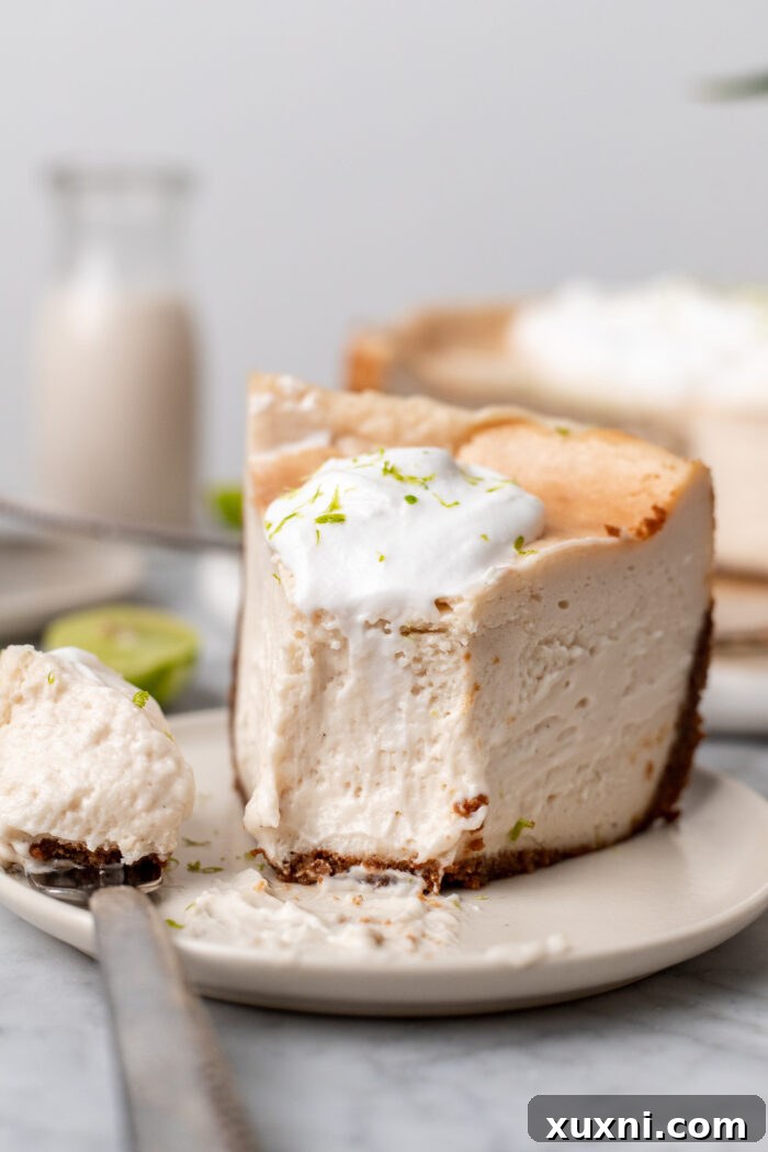 A perfect slice of vegan key lime cheesecake on a white plate