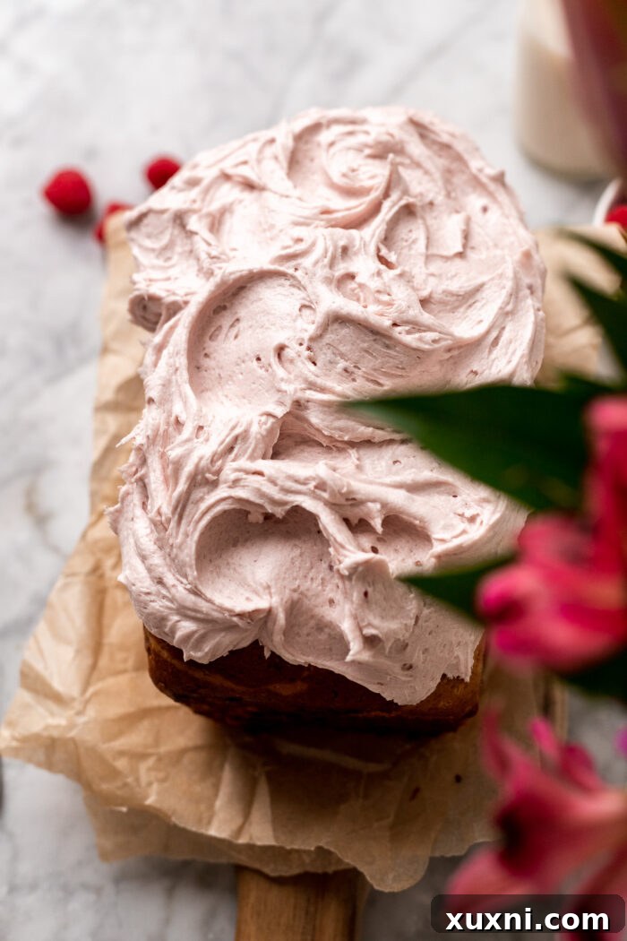 Frosted vegan raspberry pound cake with a generous layer of raspberry buttercream