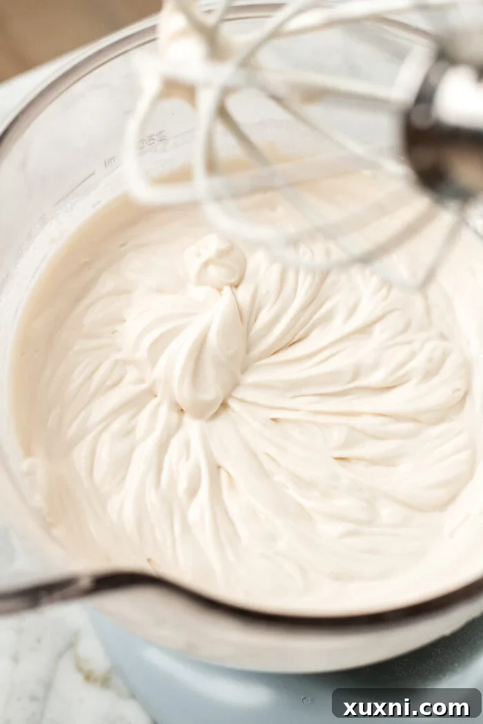 Cream cheese, sugar, and heavy cream mixture being whipped until fluffy and light, before adding Nutella.