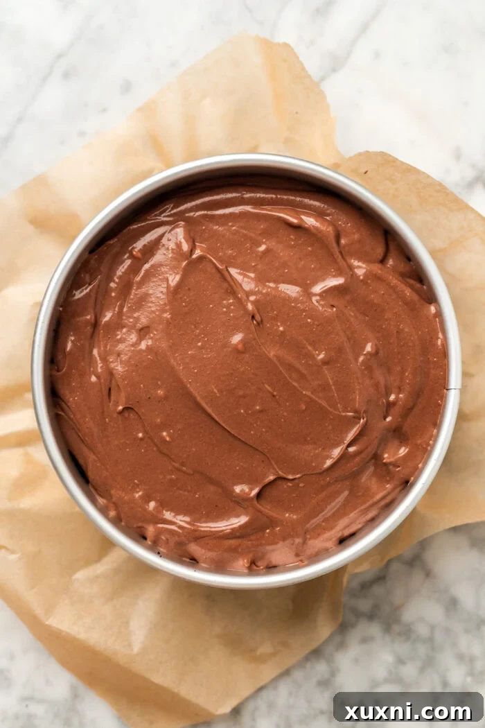 Unchilled Nutella cheesecake batter poured into the Oreo crust in a springform pan.
