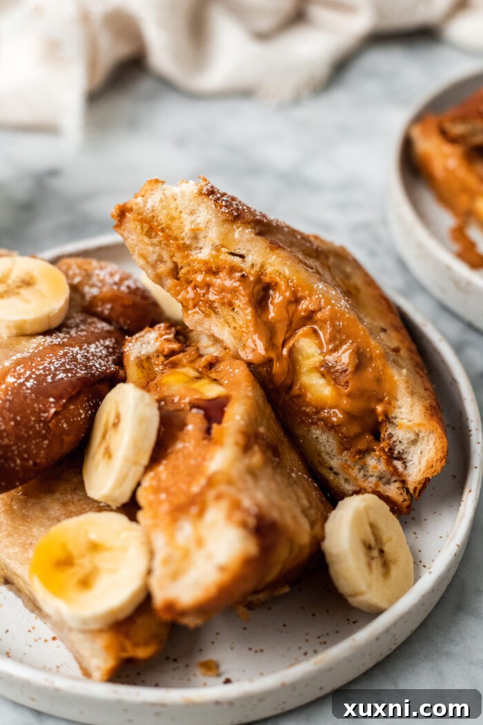 close up of French toast with peanut butter and banana on a plate 