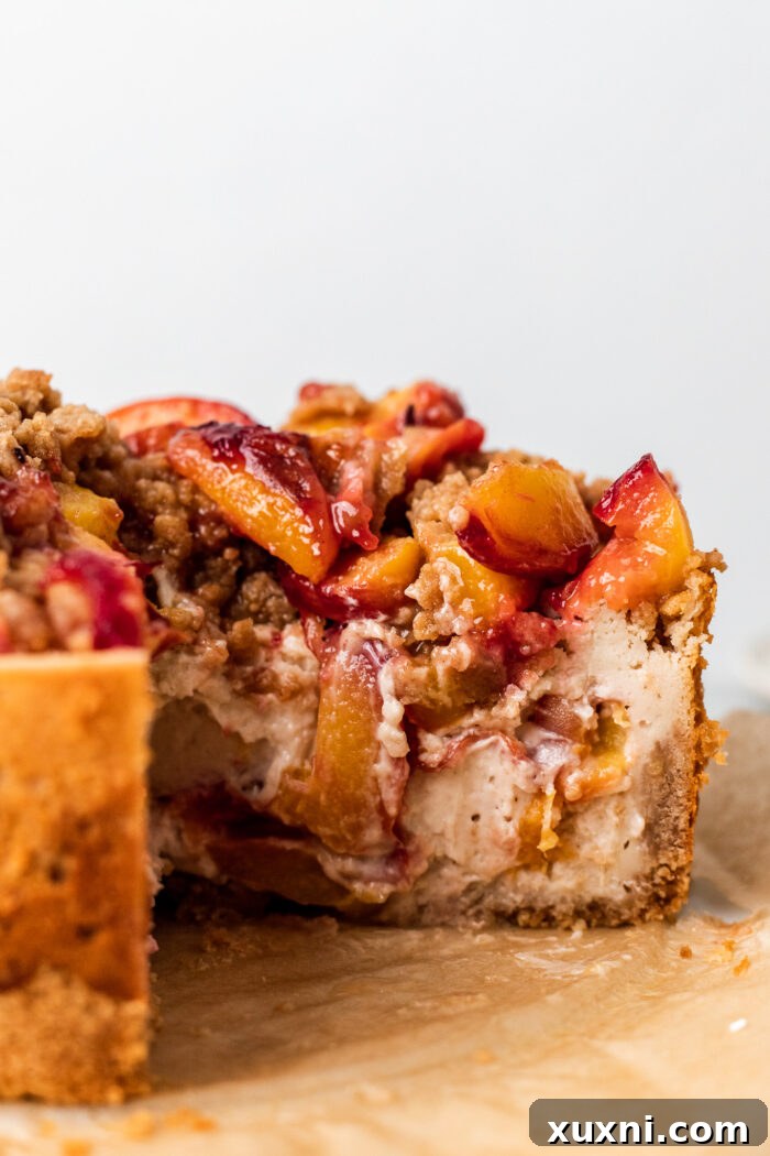 Another enticing slice of vegan peach cobbler cheesecake, highlighting the creamy filling and golden crust.