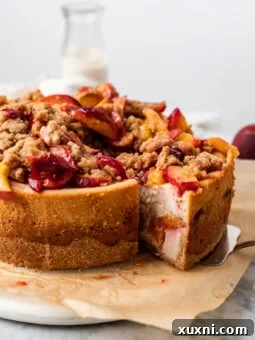 Sliced vegan peach cobbler cheesecake, ready to be served, showing off its creamy layers.