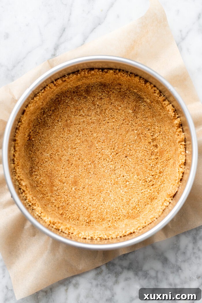 Golden-brown cookie crust pressed into a springform pan, ready for the next layer.